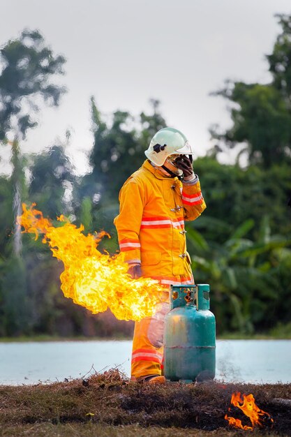 Durante l'addestramento serbatoi di gas antincendio con fuoco Vigile del fuoco con fuoco e tuta per la protezione