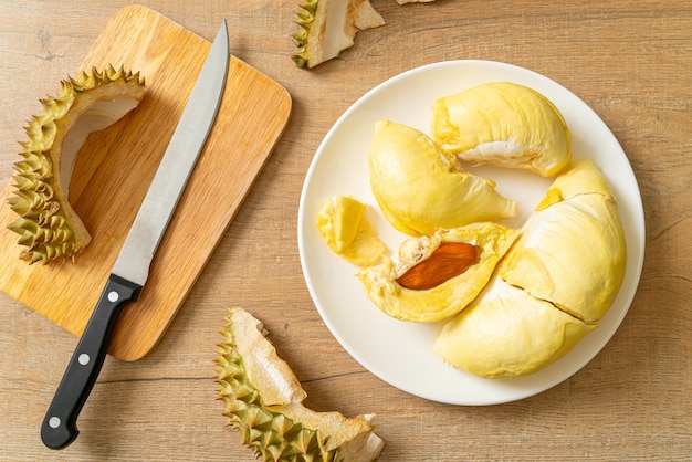 Durian stagionato e fresco, buccia di durian su piatto bianco