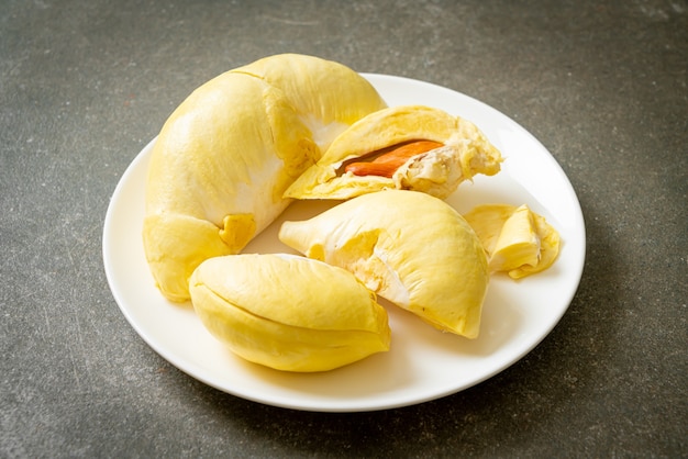 Durian stagionato e fresco, buccia di durian su piatto bianco