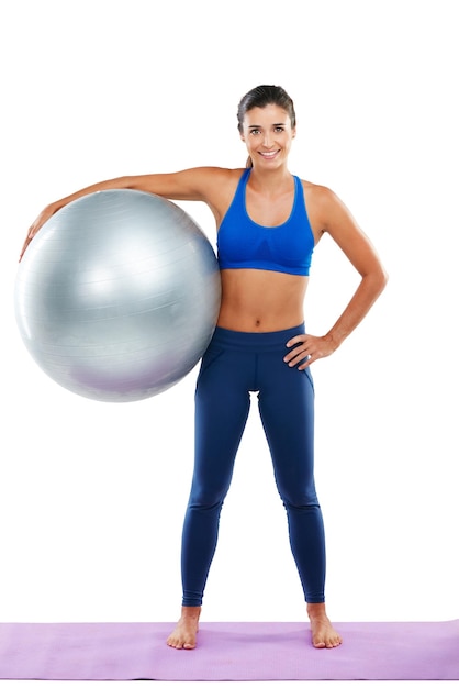 È il modo migliore per esercitare Ritratto di una giovane donna sportiva in possesso di una palla da ginnastica su uno sfondo bianco