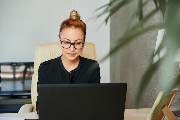 E-mail della lettura della donna di affari sullo schermo del computer portatile