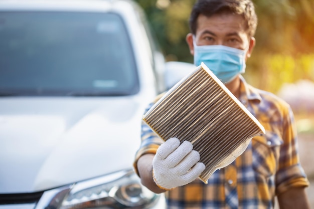È ora di cambiare il filtro dell'aria Uomo che tiene il filtro del condizionatore d'aria per auto vecchio e sporco