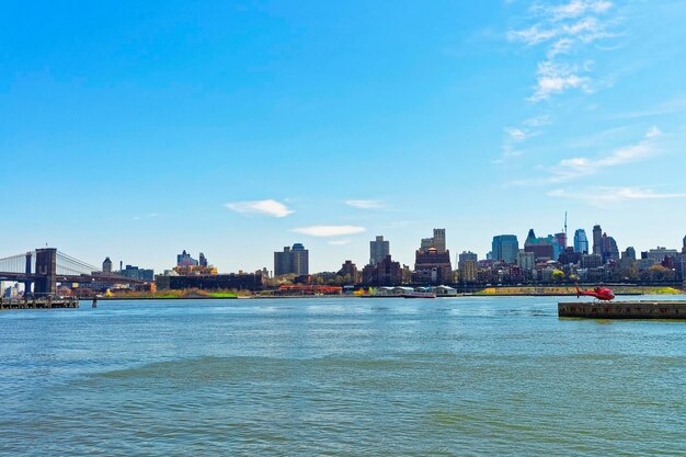 East River e il lungomare di Brooklyn, New York City, Stati Uniti. Elicottero e ponte di Brooklyn e ponte di Manhattan sullo sfondo. Vista da Lower Manhattan