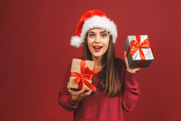 Eccitata donna sorpresa in abito rosso di Babbo Natale che tiene presente