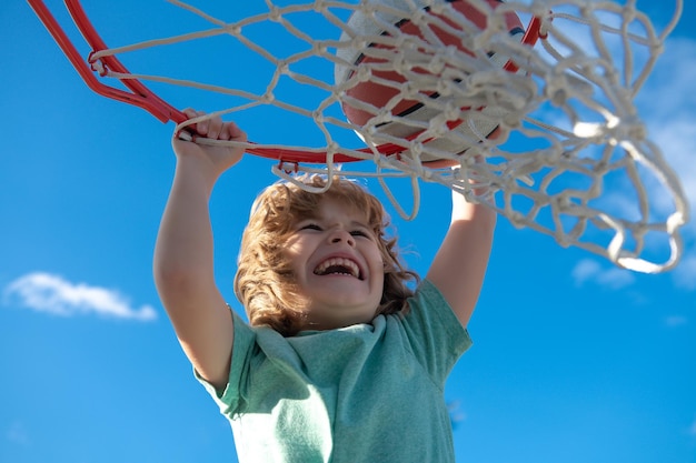 Eccitato bambino divertente che gioca a basket primo piano bambino ritratto divertente bambino faccia sportiva