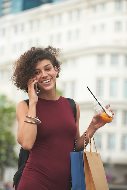 Eccitato giovane donna che parla al telefono