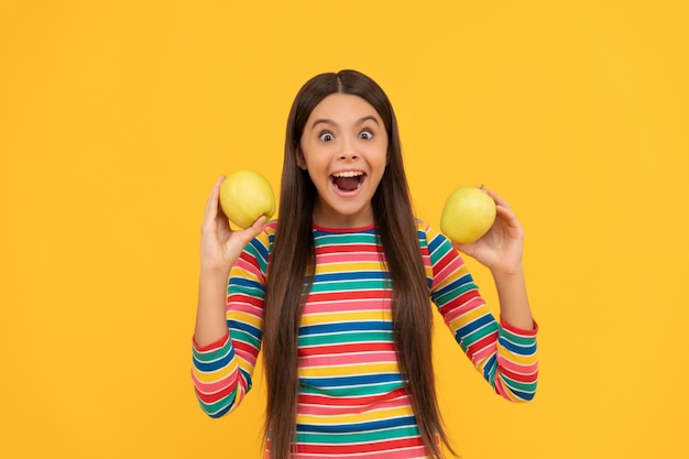 Eccitato ragazza bambino tenere mele per denti sani sfondo giallo dieta dentale