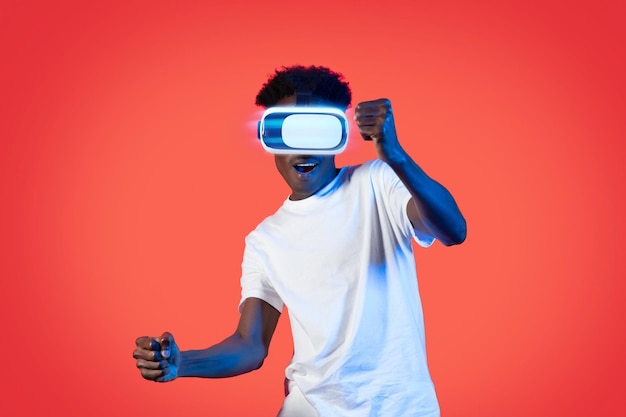 Eccitato ragazzo nero che usa l'auricolare VR alla guida di un'auto