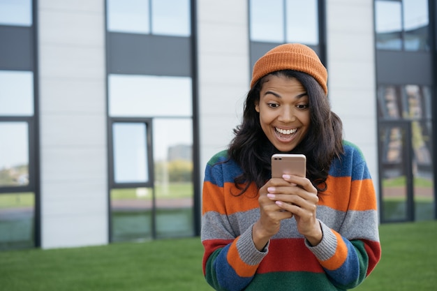 Eccitato uomo afroamericano utilizzando il cellulare