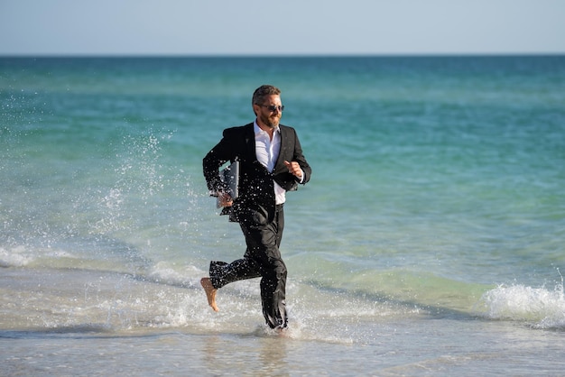 Eccitato uomo d'affari in muta correre in mare divertente uomo d'affari pazzo concetto di business comico a distanza