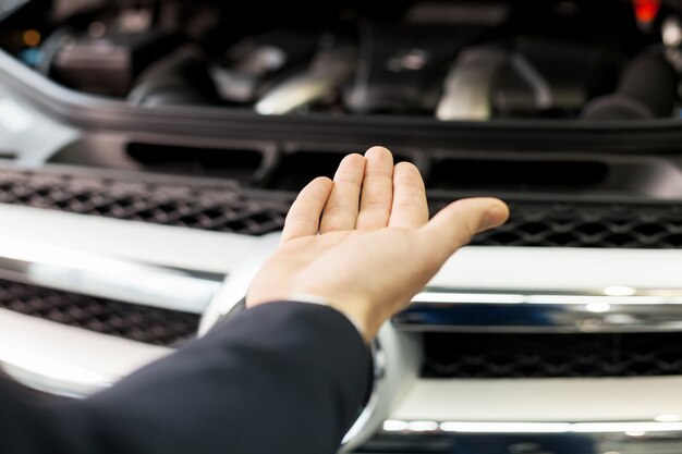 Ecco la tua nuova macchina. Primo piano della mano che presenta un'auto