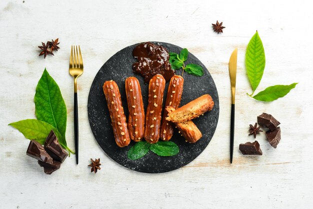 Eclair con crema al caramello Dessert al caramello e noci su una lastra di pietra nera Vista dall'alto Stile rustico