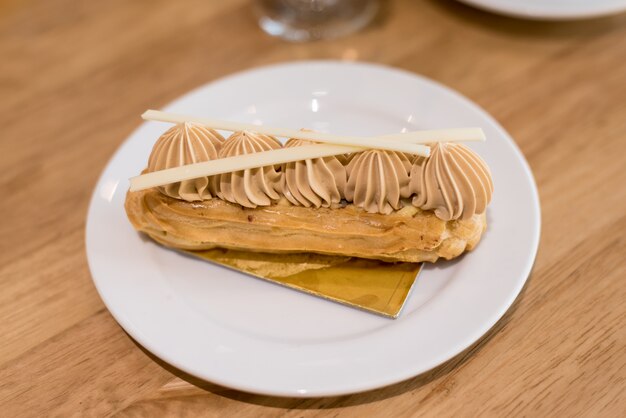 eclair di caffè francese sul piatto con una tazza di tè