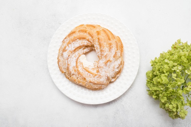 Eclair di torta alla crema e ortensie su sfondo grigio