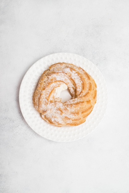 Eclair di torta di crema pasticcera su piatto bianco su sfondo grigio