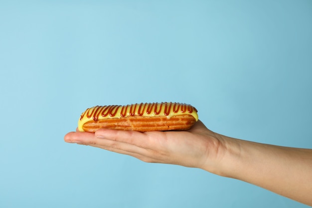 Eclair gustoso della stretta della mano femminile sull'azzurro