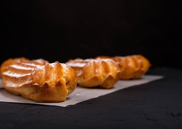 Eclairs con crema su uno sfondo scuro