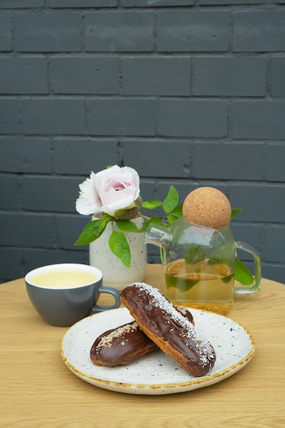 Eclairs con tè su un tavolo in un caffè Cibo dolce ancora in vita