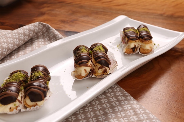 Eclairs con topping al cioccolato, squisito tortino al cioccolato, pasta ekler