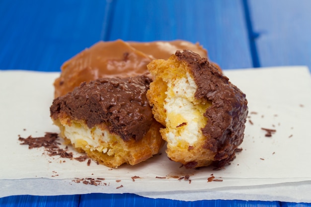 Eclairs di Choclate su Libro Bianco su superficie di legno