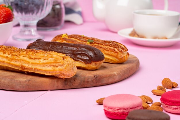 Eclairs fatti in casa della torta sulla tavola rosa