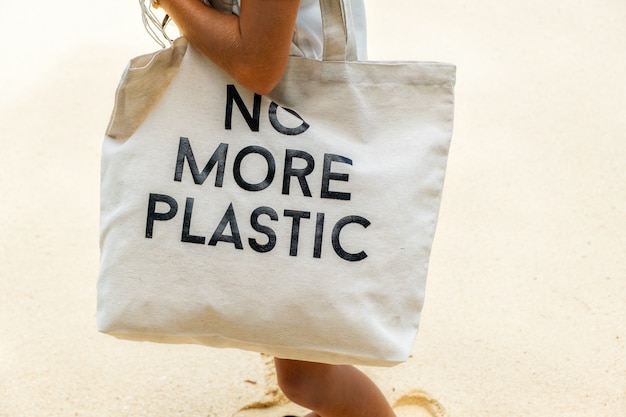 Eco bag con cartello NON PIÙ PLASTICA sulla spalla della ragazza