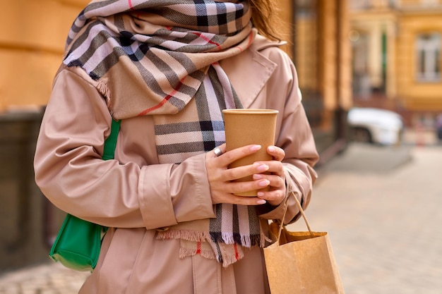 Eco shopping, donna irriconoscibile che beve caffè per strada dopo aver fatto shopping a piedi per la strada della città