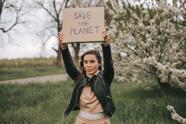 Ecoattivista femminile che tiene il cartello con il riciclo salva il pianeta