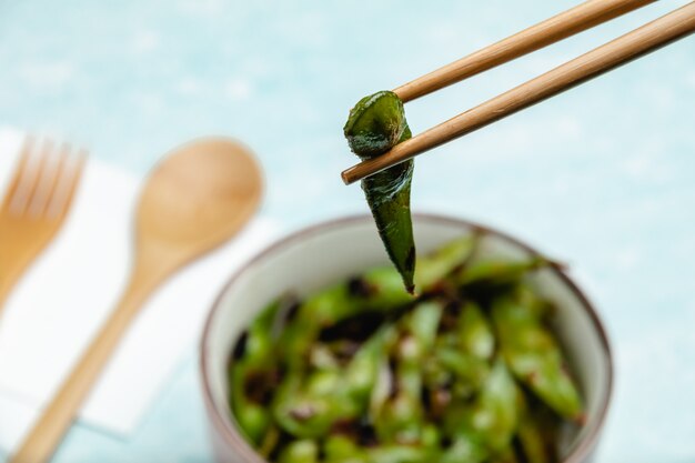 Edamame cotto su un tavolo blu. Snack baccelli di soia