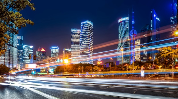 Edifici della città di Shanghai di notte e luci auto sfocate