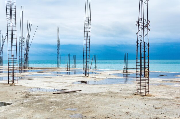 Edificio al grezzo con armature sporgenti in riva al mare