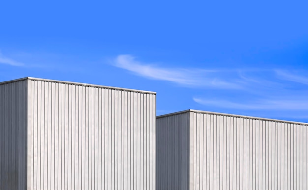 Edificio di due capannoni industriali in metallo ondulato su sfondo blu cielo