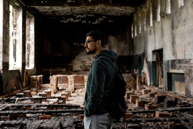 Edificio distrutto Edificio bruciato Finestre rotte con cenere Un uomo in un edificio bruciato distrutto