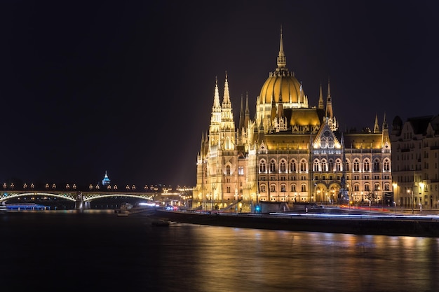 Edificio illuminato del parlamento ungherese in città sul fiume Danubio di notte
