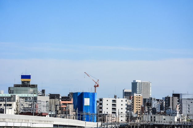 Edificio in costruzione nel centro di Tokyo con paesaggio urbano e cielo blu sullo sfondo