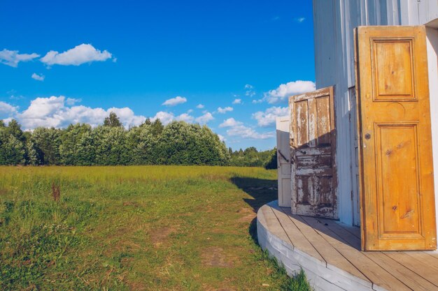 Edificio in legno bianco con molte porte con vista su un prato verde prato