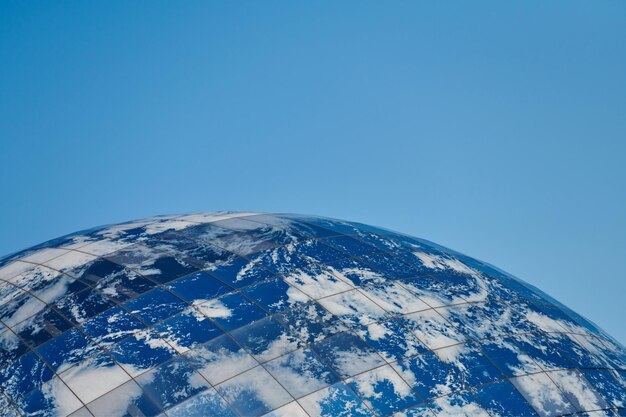 Edificio moderno del pianeta terra con le nuvole e il concetto architettonico ecologico del cielo blu