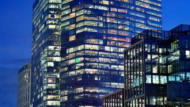 Edificio per uffici di sera con spazi di lavoro illuminati Moderno grattacielo vetrato in finanza