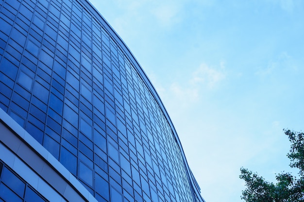 Edificio per uffici in vetro a più piani contro il cielo