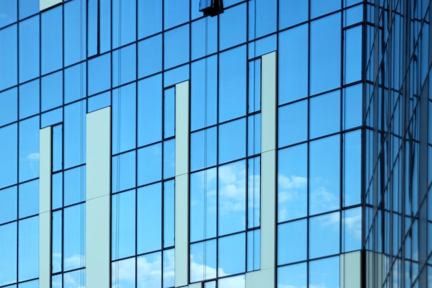 Edificio per uffici in vetro, vista del cielo riflessa nelle finestre.