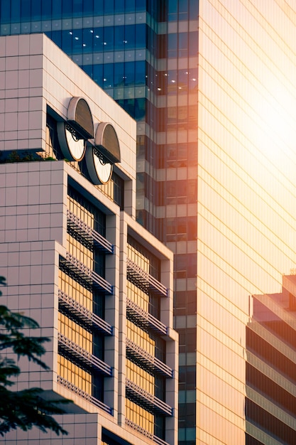 Edificio per uffici moderno bianco con luce solare sulla superficie della parete di vetro del grattacielo in serata