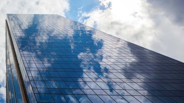 Edificio per uffici moderno blu con la riflessione delle nuvole
