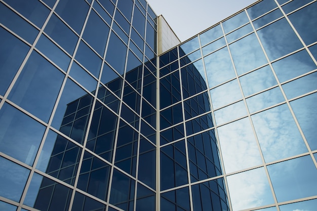 Edificio per uffici moderno con le finestre di vetro ed il cielo blu. Consistenza del grattacielo.