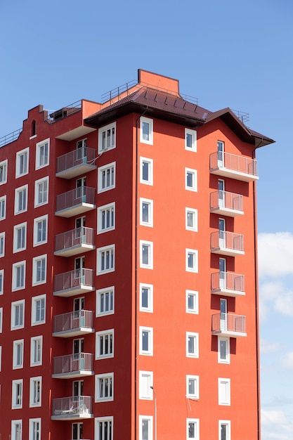 Edificio residenziale multipiano arancione con finestre bianche contro il cielo blu