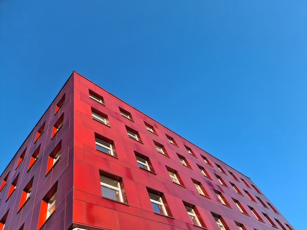 Edificio rosso multipiano in piedi sullo sfondo del cielo blu