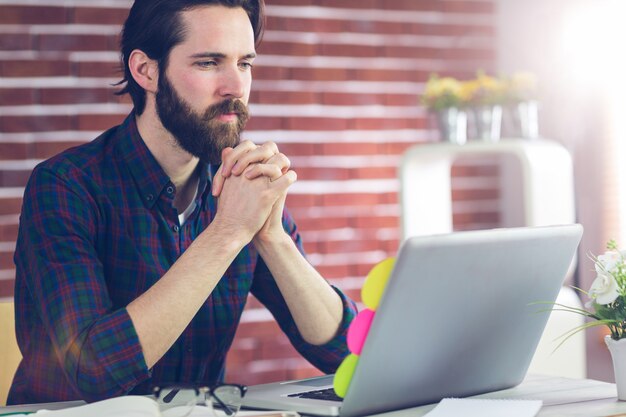 Editor focalizzato con la mano stretta con il laptop