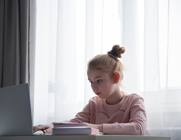 Educazione a distanza. Una studentessa che studia i compiti durante la lezione online a casa tramite Internet. Distanza sociale durante la quarantena
