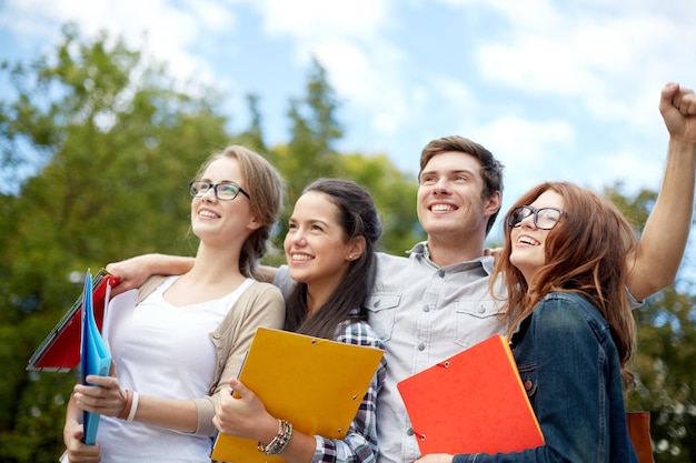 educazione, amicizia, successo e concetto adolescenziale - gruppo di studenti felici che mostrano un gesto di trionfo al campus o al parco