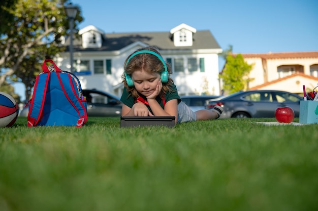 Educazione dei bambini Scolaro con materiale scolastico in giardino Bellissimo ragazzo è felice di apprendimento