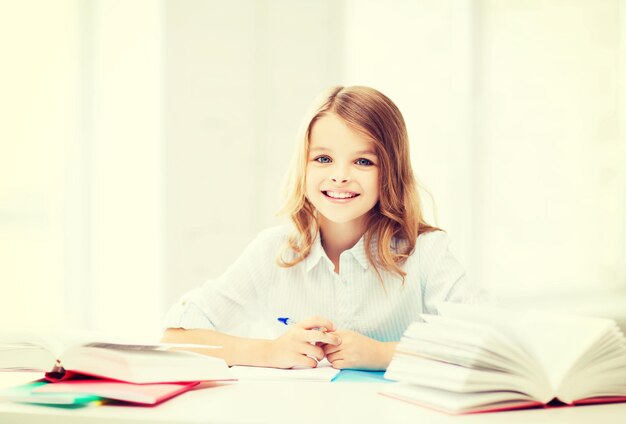 educazione e concetto di scuola - piccola studentessa che studia a scuola